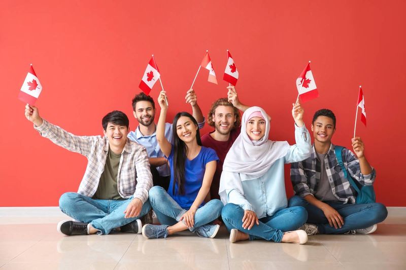 multi-ethnic people holding Canadian flags 